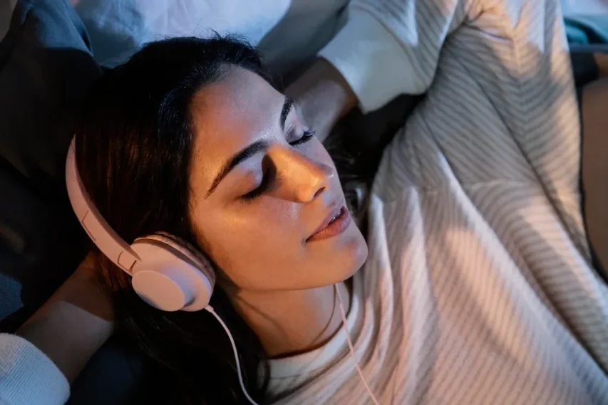 5 Terapias Inusitadas para Relaxar a Mente: Do Banho de Floresta ao Poder do Riso 2 terapia do som mulher usando fones