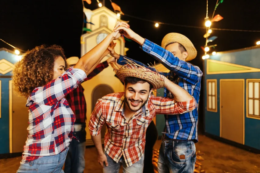 Festa Junina: Tudo Sobre a Mais Alegre Tradição do Ano! 3 pessoas brincando com roupas típicas